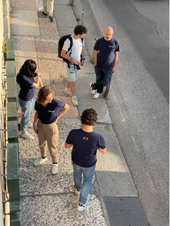 Ritratto di alcuni membri del team visti dall'alto mentre sono in strada a girare delle riprese.