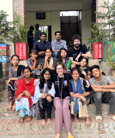 Gruppo di ragazzi locali in Bangladesh sorridenti accanto a volontari di Skillando.