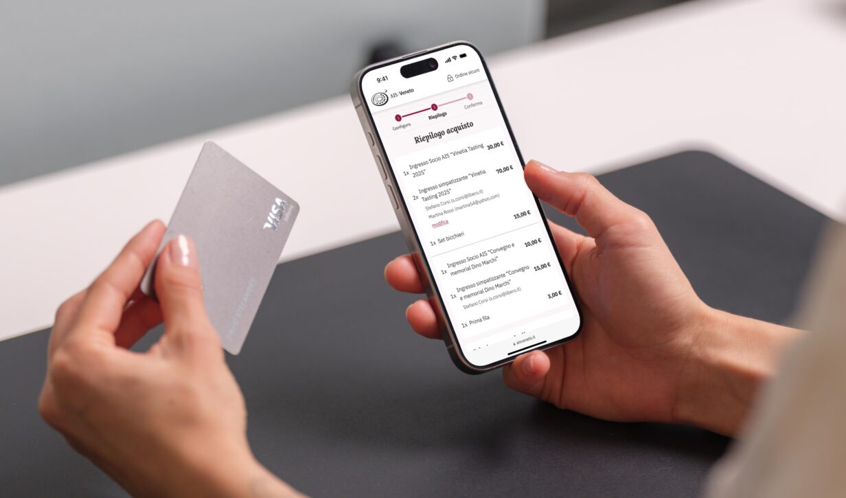 Smartphone in mano con l'app di pagamento AIS Veneto aperta, evidenziando il riepilogo acquisto.